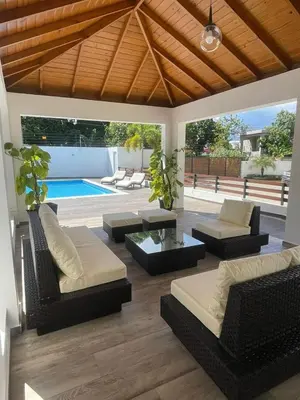 a patio with couches and a table and a pool at Ático fantástico in Santiago de los Caballeros
