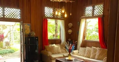 a living room with a couch and two windows at Rancho Fernandez in Jarabacoa