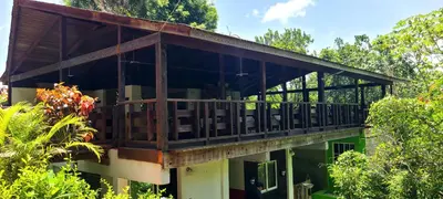 a building with a balcony in the middle of trees at Rancho Fernandez in Jarabacoa