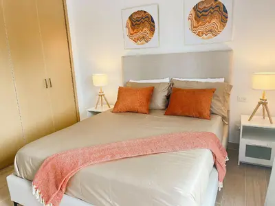 a bedroom with a large white bed with orange pillows at Beauty condo pool views with gym close to the beach in Punta Cana