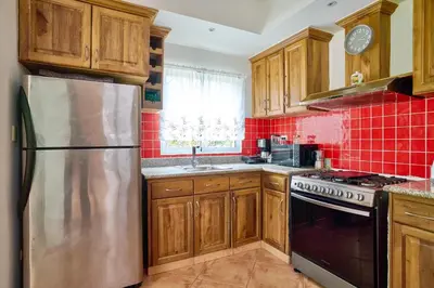 a kitchen with wooden cabinets and a stainless steel refrigerator at Serene Beach Haven In Las Terrenas in Las Terrenas
