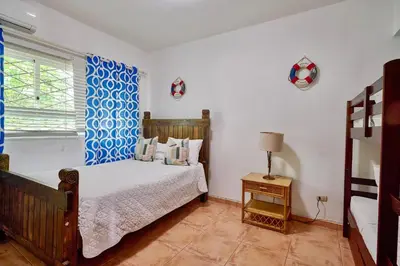 a bedroom with a bed and a blue and white curtain at Serene Beach Haven In Las Terrenas in Las Terrenas
