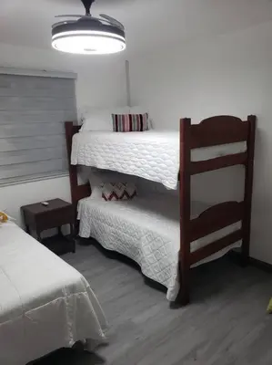 a bedroom with two bunk beds and a chair at Los Robles in Santo Domingo