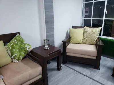 a living room with two chairs and a coffee table at Los Robles in Santo Domingo