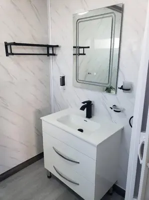 a white bathroom with a sink and a mirror at Los Robles in Santo Domingo
