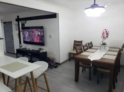 a dining room with a table and chairs and a tv at Los Robles in Santo Domingo