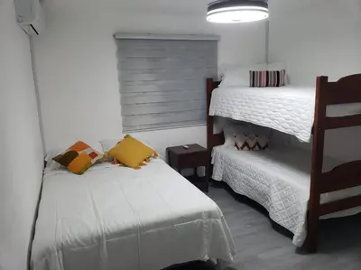 a bedroom with two beds and a small bed at Los Robles in Santo Domingo