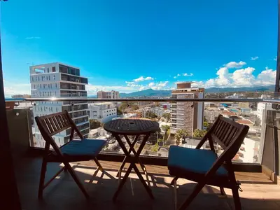 two chairs and a table on a balcony with a view at Condo hotel rialto Recidences in Santiago de los Caballeros