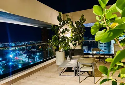 a balcony with a view of a city at night at Condo hotel rialto Recidences in Santiago de los Caballeros