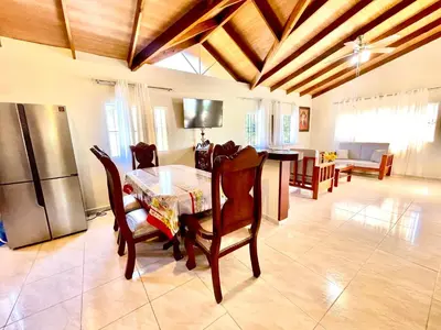 a kitchen and dining room with a table and a refrigerator at Encantadora Terraza de Brisas Frescas in Jarabacoa