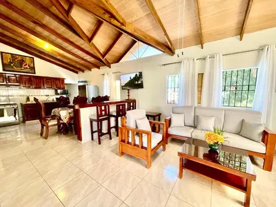 a living room with a couch and a table at Encantadora Terraza de Brisas Frescas in Jarabacoa