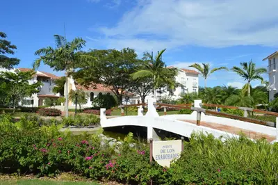 a bridge over a pond in a park with houses at Apartment in Cadaques Caribe in Bayahibe
