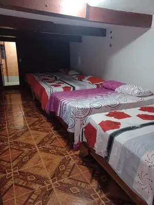 three beds in a room with tile floors at villa mariposa in Santo Domingo