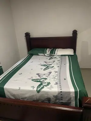 a bed with a green and white blanket on it at villa mariposa in Santo Domingo