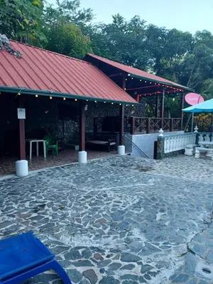 a stone patio with a building with a red roof at villa mariposa in Santo Domingo