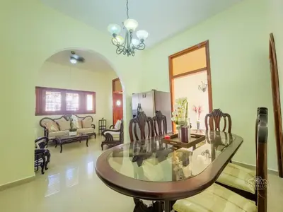 a living room with a glass table and chairs at Charming Colonial Santo Domingo in Santo Domingo
