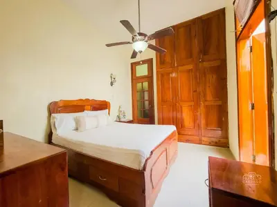 a bedroom with a bed and a ceiling fan at Charming Colonial Santo Domingo in Santo Domingo