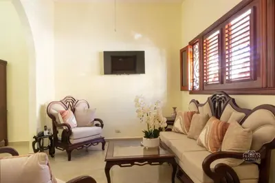 a living room with a couch and two chairs at Charming Colonial Santo Domingo in Santo Domingo