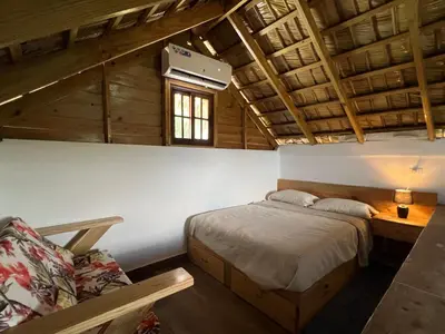 a bedroom with a bed and a desk and a window at Villa Tierrita in Santa Bárbara de Samaná