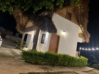 a small white house with a brown door at Villa Tierrita in Santa Bárbara de Samaná