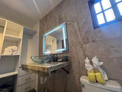 a bathroom with a sink and a mirror over the toilet at Villa Tierrita in Santa Bárbara de Samaná