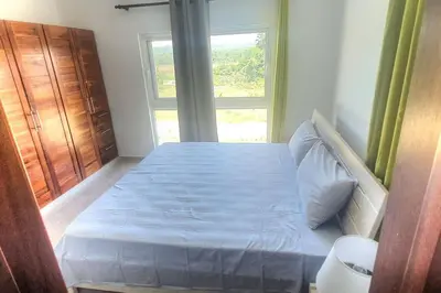 a bedroom with a blue bed with a window at 2 Bedroom Pool Villa in Gated Encuentro Residences by Palm Hills Real Estate in Cabarete