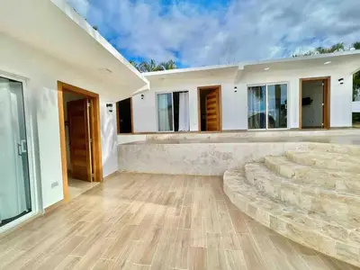a large living room with a large couch in front of a house at Exclusive Paradise Palms Villa in Sosúa