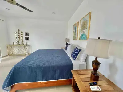 a bedroom with a bed and a table with a lamp at Exclusive Paradise Palms Villa in Sosúa