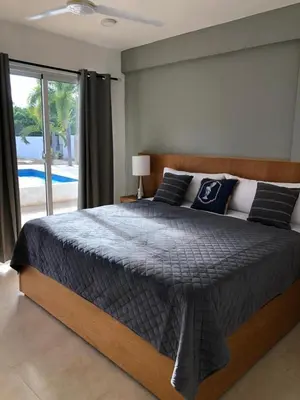 a bedroom with a large bed and a large window at Exclusive Paradise Palms Villa in Sosúa