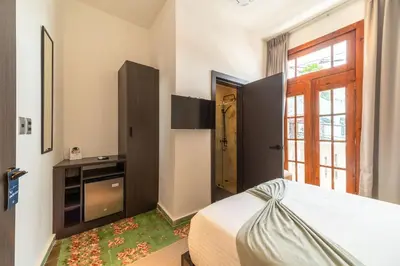a bedroom with a bed and a window and a door at Empyrean Art Deco in Santo Domingo