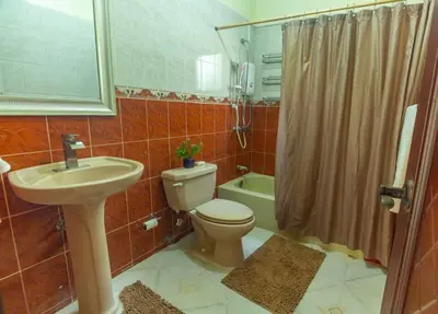 a bathroom with a toilet and a sink and a shower at Villa Infinito Bani's Exclusive Beachside Mansion in Baní