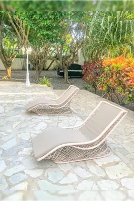 a pair of chairs sitting on a stone patio at Villa Infinito Bani's Exclusive Beachside Mansion in Baní