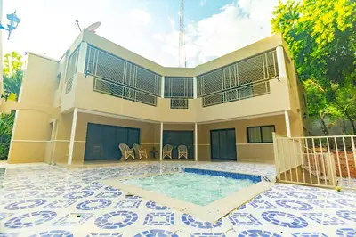 a house with a swimming pool in front of it at Villa Infinito Bani's Exclusive Beachside Mansion in Baní