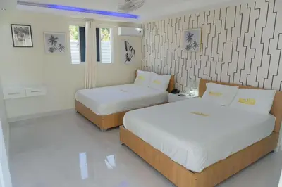 two beds in a room with white walls at Hotel1325 in Baní