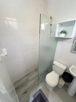a bathroom with a toilet and a glass shower at Hotel1325 in Baní