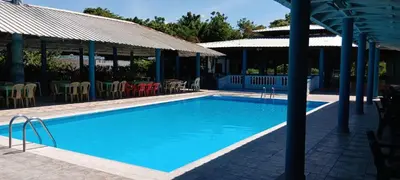 a large blue swimming pool with chairs and umbrellas at Hotel1325 in Baní