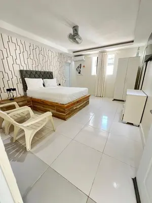 a bedroom with a bed and a white tiled floor at Hotel1325 in Baní