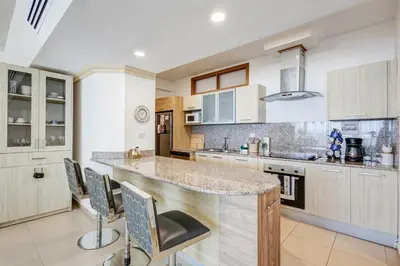 a kitchen with a large counter with chairs around it at Huge Lux 3br Beachfront Condo Wifi Fast in Paraíso