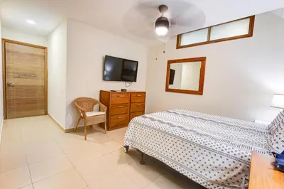 a bedroom with a bed and a dresser and a tv at Huge Lux 3br Beachfront Condo Wifi Fast in Paraíso