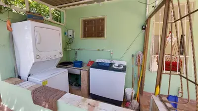 a small kitchen with a refrigerator and a washer at Increible Casa Con Piscina! in Los Frailes