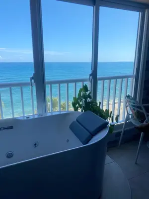 a bath tub in a room with a view of the ocean at Mar & Relax in Santo Domingo