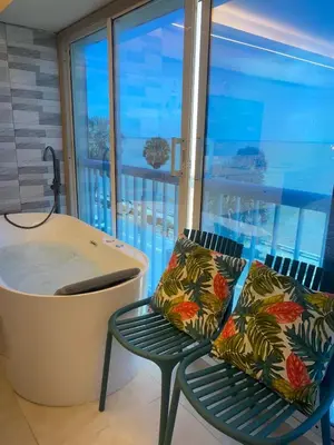a bathroom with a tub and a chair next to a window at Mar & Relax in Santo Domingo