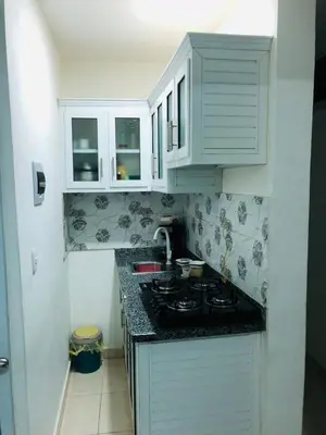 a kitchen with white cabinets and a stove top at Apartamento Acogedor in San Felipe de Puerto Plata