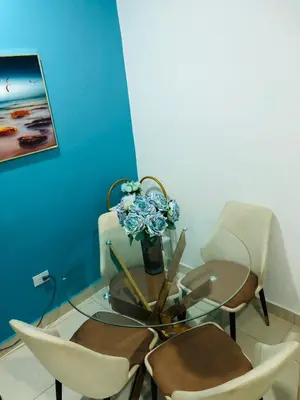 a table with chairs and a vase with flowers on it at Apartamento Acogedor in San Felipe de Puerto Plata