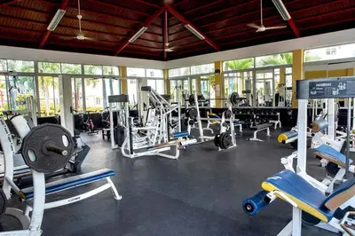 a gym with a lot of treadmills and machines at Relax in this apartment in Santiago de los Caballeros