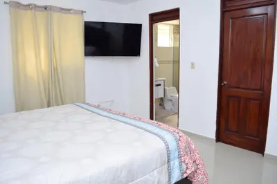 a bedroom with a bed and a flat screen tv at Relax in this apartment in Santiago de los Caballeros