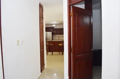 two views of a kitchen and a hallway with a door at Relax in this apartment in Santiago de los Caballeros