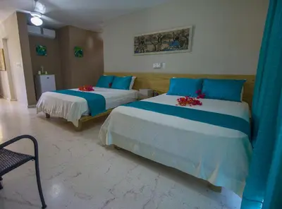 two beds in a room with blue and white at Paradise Island Beach Resort in Punta Rucia
