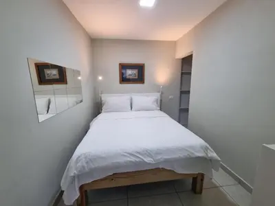 a small bedroom with a bed with white sheets at Apartamento Estudio Puerto Plata in San Felipe de Puerto Plata