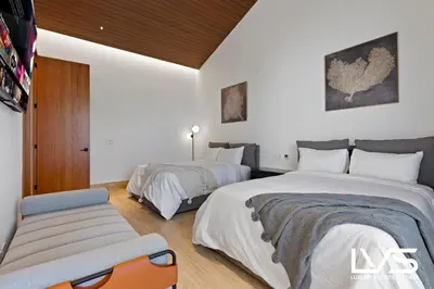 a bedroom with two beds and a chair at Zen Oasis Villa at Casa de Campo in La Romana